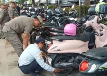 Puluhan sepeda motor yang kedapatan parkir liar di trotoar dirantai petugas gabungan