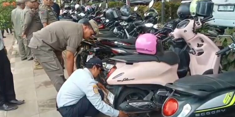Puluhan sepeda motor yang kedapatan parkir liar di trotoar dirantai petugas gabungan