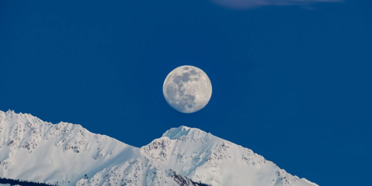 ilustrasi snow moon saat bulan terlihat jelas di malam hari dengan salju