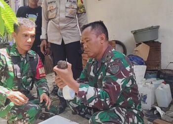 Petugas kepolisian bersama anggota TNI dari Denpal III Cirebon memeriksa benda yang diduga granat (Foto : Darfan)