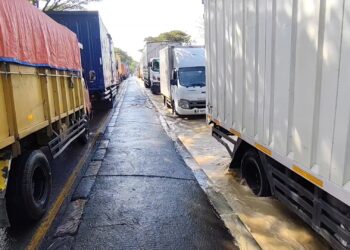 Petugas menerapkan contraflow bagi kendaraan roda dua yang tidak bisa melewati banjir (Foto : Darfan)