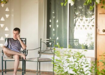Seorang yang sedang bersantai di teras rumah dengan cuaca cerah. (Sumber Foto : Freepik)