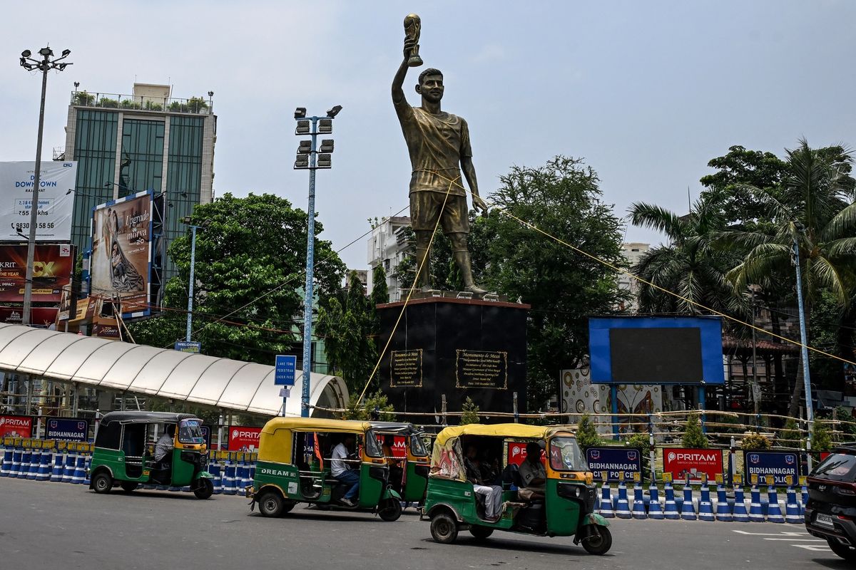 Sejumlah bajaj melewati patung raksasa Lionel Messi yang menjulang setinggi 21 meter di Kolkata, India, 27 Mei 2026. Patung ini bergoyang tertiup angin dan rawan roboh.(AFP/DIBYANGSHU SARKAR)