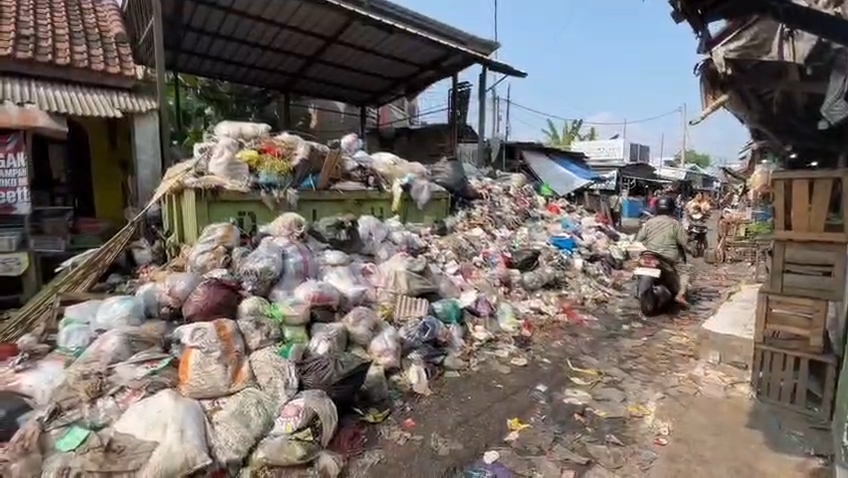 Gunungan sampah hingga meluber menutup jalan di tempat pembuangan sampah Pasar Minggu, Kabupaten Cirebon (Foto : Darfan)