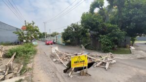 Jalan Tangkil Gede di Kelurahan Watubelah, Kecamatan Sumber, Kabupaten Cirebon, mengalami ambles hingga membentuk lubang besar yang hampir menutup seluruh badan jalan (Foto : Darfan)