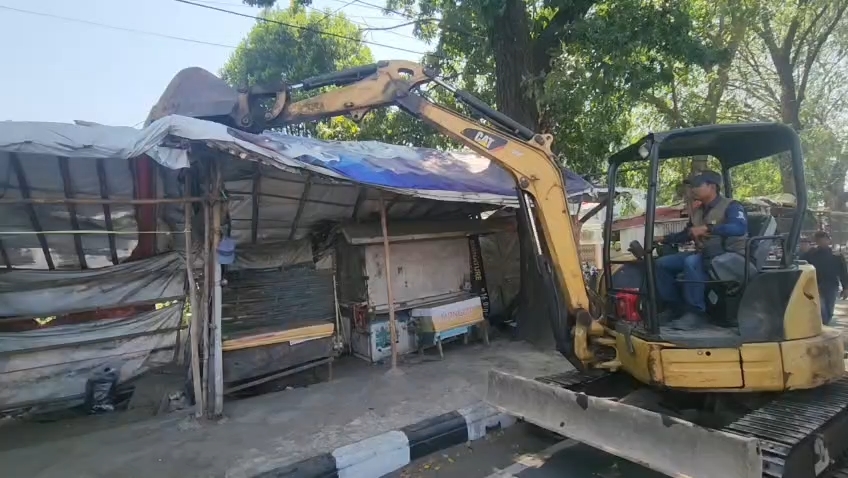 Petugas gabungan menertibkan bangunan liar dan reklame di Jalan Kesambi, Kota Cirebon. (Foto : Darfan)